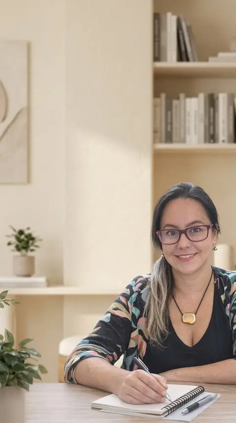 Nury Müller, psicóloga, sonriendo en su consulta para sesiones de terapia online